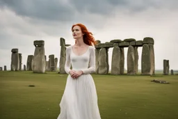 A tall slim red-headed woman, in a white floaty dress, standing in front of Stonehenge