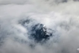large scale, far away. a massive sheer snowy mountain cliff with very sparse vegetation scaling vertically into the sky, partially obscured by dense clouds(color d0d1d5) and mist. the borders — top, bottom, left, and right — fade smoothly into thick fog, while the center reveals the steep, far away rocky cliff face with fine texture and detail. atmospheric lighting, cinematic composition, natural colors, high contrast between fog and stone. photography