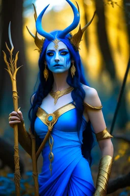 A picture of a beautiful blue faced indian goddess with skin painted blue, blue painted body, blue painted torso, wild black hair, stag antlers, elven ears, golden skirt, holding a staff in a sunny forrest