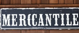 fill composition with large and wide hand painted old western sign that reads: "MERCANTILE" white on black with inset white stripe aged paint on wood sanserif