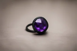 небольшое чёрное кольцо с приделанным лиловым камнем на пол.