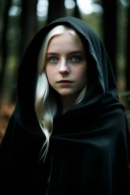 девушка с прямыми белыми волосами, синими глазами, веснушками на щеках в чёрной мантии на фоне леса