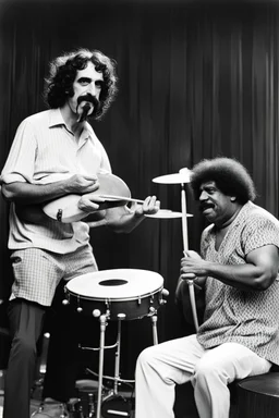 Frank zappa playing bongos next to a very fat black man