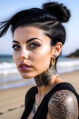 Beautiful young woman in her early twenties with black hair worn up in a bun, brown eyes, soft features, and a sleeve of tattoos on a beach