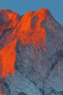 big rock mountains with and orange dawn sky with no clouds close montains