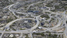 busy alien town, with people, alien buildings, curved roads, vehicles, and spaceships, from ground level