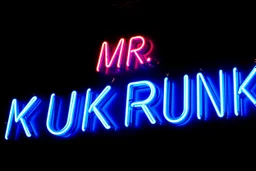 a very big blue whita neon sign that say "MR. KUKRUNK" , black background, flashes and sparks