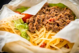 "Taco in a Bag" which consists of an open Doritos chip bag containing Doritos chips and cooked ground beef and lettuce and shredded cheese and tomato pepper and onions, food blogger photography