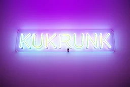 A simple neon sign labeled "KUKRUNK" white background and bold 80s font