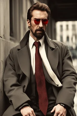 a young man with big muscles who looks like hans gruber wearing a heavy coat and red sunglasses staring with an irritated look on his face