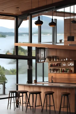 Intérieur cuisine avec bar dans Maison montagne design bois et béton devant baie en verre avec vue sur un lac Lumière soleil couchant