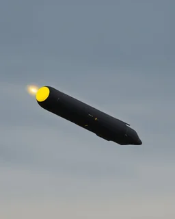 A black missile flying in the sky with a yellow dot