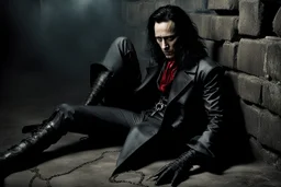 Action shot of Tom Hiddleston as Alucard from the live action "Hellsing" movie based on the anime of the same name. He is sitting, arms chained to a dungeon wall. He appears to be corpse wearing black wrappings that cover all except his head, feet, and hands. His straight, black hair hangs to the floor. A vague smile is on his gaunt face.
