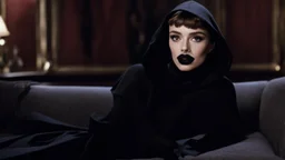 [Legend (1985)] Audrey Hepburn's Boyish Crop as Dahlia Death, she is a pale brunette with black lipstick clad in a dark agent provocateur dress with a hoodie and a scythe. She sits on a sofa in a dark mansion