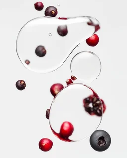 pomegranate seeds behind water drops on a white background