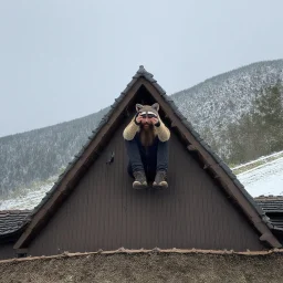 bearded man in a coon skin cap sitting on the roof of a rustic triangular shaped cottage holding a smart phone up over his head trying to get a signal, mountainous terrain, patchy snow on the ground and on the roof, cloudy day, photographic