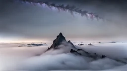 looking up at misty foreground and night sky background, no sun, single sharp narrow mountain peak coming through the mist in the center