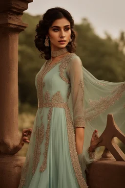 A powder blue anarkali suit with a high-low hem and a flowy silhouette.The bodice is heavily embroidered with intricate threadwork and sequins in a floral pattern.The dupatta is a sheer mint green with scalloped lace borders.