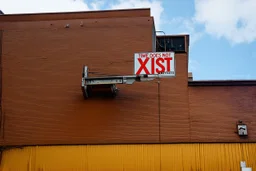 an arafed street sign hanging on the side of a building with text "TIME DOES NOT XIST", concept art, street art:2, war art, surrealism aesthetic, time does not exist anymore, three, plus - x,, infinite space clock background, rust background, oilpunk, lithographics, futuristic typography, paradox, fallout, inevitability, connectedness, amazing reflections, great verticals