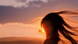 Silhouette of the head of a young lady with long flowing hair in a slight breeze. At sunset in Czech nature.