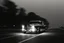Placeholder: Coche Cadilac americano en mitad de la noche tan sólo iluminado por una farola y los faros del coche, imagen en blanco y negro vaporoso, imagen al estilo del fotógrafo Hugo Alonso
