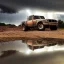 Placeholder: hyperrealistic shot, off-road truck, speeding, earth color palette, sharp focus, puddle reflection, tire water splash, refraction, rain and lightning on the horizon, shadowcast, detailed and intricate, cinematic composition, tilt shift photography