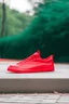 Placeholder: red sneaker on outdoor background without logo