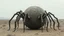 Placeholder: A large, spherical object that appears to be a spider. The object is in the center of the image, with its body facing towards the left side of the frame. It has a long, slender body with multiple legs that extend outwards from its body. The legs are covered in small, dark hairs that are curled and twisted, creating a web-like appearance. The body of the object is covered in a layer of dust and dirt, giving it an eerie and eerie appearance. The background is a barren landscape with no other objec