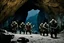 Placeholder: three menacing orcs [high res photo from the Lord of The Ring movie (JRR Tolkien)] the entry of a cave in the mountain, during the night, three orc warriors are guarding the entrance facing the camera, observed from behind a rock