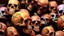 Placeholder: a picture of a dark, comedic, anatomically correct wall of colorful tightly packed stacked cyborg skulls of varying sizes and expressions, photo realistic, insanely meticulous, highly detailed, part of a collection of bones on display, 64k, dystopian, vray