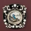 Placeholder: coaster of kingfisher ivory brooch with black pearl inlay, opalescent marble carving, decorative design, classical ornament, highly ornate, highly intricate, highly detailed etching, marble carving, warm lighting, linen backdrop