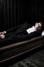 Placeholder: a man in black suit, white shirt, black pants, black shoe sleeping in a coffin