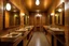 Placeholder: Pictures of a group of bathrooms in Mathaf Restaurant. The walls and floors are brown in shades, the sinks are on one wall, and the toilet doors are opposite the sinks.