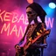 Placeholder: a very thin swedish man (near skeleton), with a plague mask with only a hole for the mouth (no eyes), he is called "KEBAB MAN" performing at death metal club, his name is "KEBAB MAN" kebab rolls On stage, kebab Neon lights and smog, and "KEBAB MAN" big sign on the wall, kebab tribal tattooes, spinning kebab machines, flames and smoke, chaos, he playing a metal guitar with flames