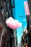 Placeholder: A pink plastic cloud floating in the street, sunny