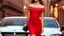 Placeholder: full body shot of young, beautiful Ozbek brunette with a perfect happy face with make up, wearing red lace off shoulder dress, over a luxury roof less car in amodern city street.