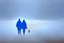 Placeholder: two people without gender seen from behind walking side by side in an empty foggy plain, above there is blue sky