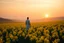 Placeholder: A vast, tranquil landscape bathed in the golden glow of a spring sunset, with a sea of daffodils stretching across rolling hills under a soft, pastel-colored sky. The flowers sway gently in a soft breeze, creating a vibrant, dream-like ocean of yellow against the serene background. close up on A solitary figure, perhaps a poet or dreamer, stands in awe at the beauty, their presence almost blending with the natural scenery. The atmosphere is ethereal, with surreal lighting