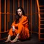 Placeholder: Beautiful 25 year old woman sitting wearing an orange prison jumpsuit and bare feet. dark fantasy