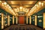 Placeholder: Inside an Art Deco cinema with mirrors and brass sconces, incandescent, gleaming