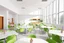 Placeholder: A 3D hyperrealistic 3D image in 4K resolution of a modern party and birthday room (about 100 sq m) with arranged tables, big windows , green chairs, lots of light and a kitchenette.