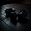 Placeholder: Hexagon dumbbells pair of two, each 12.5KG. Inside a dark and moody gym on the black rubber tile floor. Bird perspective on the dumbbells laying on the floor.