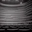 Placeholder: a close up of a single chair on stage under spotlight at a dark and empty symphony hall as seen from stage