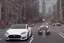 Placeholder: A Tesla 'Model 3' is racing at top speed, near the 'Statue of Liberty' in New York. CINEMATIC. WIDE ANGLE LENS. PHOTO REAL.