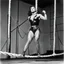 Placeholder: [high res photo by helmut newton] Oro wrestler Sherry Martel as a super heroine on the rope of the ring, ready to jump