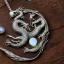 Placeholder: a gorgeous, stunning pewter necklace of a dragon clutching an illuminescent moonstone lying on a rustic wood table with crystal ball behind necklace, 8k resolution, high-quality, fine-detail, photorealistic, intricate, digital art, detailed matte, volumetric lighting, illustration, 3D octane render, brian froud, howard lyon, selina french, anna dittmann, annie stokes, lisa parker, greg rutowski, George Grie, Ben Goossens, Igor Morski