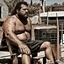 Placeholder: extreme close up photography of a sicilian ugly burly serious wet sweaty, muscular chubby strong fat carpenter, shirtless, boxer, bulge, manly chest, very hairy allover, big goatee 26 years old, curly short hair, sit sleeping with open legs on a little chair , on a construction site in the middle of a road, under the August sun, emotional eyes, , hyper-realistic, photorealistic , frontal view from the ground