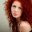 Placeholder: Woman with red curly hair and brown eyes