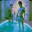 Placeholder: Handsom Justin long and his buff boyfriend are above thier pool roombath spa heater while in tight loincloths and Nickolas is flexing there muscles while illuminated by the ambient teal glowing on the glowing marbled floor made of long flat marble slabs, the ground next to the clinical yard is in the style of primitive art. metalworking mastery, fawncore, the immaculately composed quality of this photo shows the artist was taken with provia, detailed wildlife, isaac grünewald, rustic simplicity