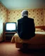 Placeholder: man with plastic bag over his head sits on the edge of a bed with his feet on the ground, facing camera, inside an old, 70s style motel room with tacky wall paper. he is wearing a black suit with a melincholy attitude. there is a box tv facing away from camera, illuminating his front. from this view, you cannot see the front of the tv. full room view, super wide shot, 24mm lens view, film syle.